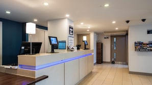 A reception area with a counter, computers, and a blue-lit desk. - Holiday Inn Express Stirling by IHG (Stirling)