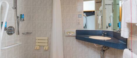 A bathroom with a shower, a sink, and a mirror.