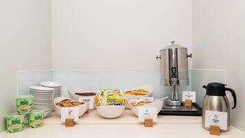 A breakfast buffet with various food items and a coffee machine.