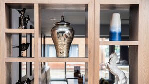 A wooden display shelf with various decorative items including a vase, a sculpture, and a cup. - Holiday Inn Express Edinburgh Airport by IHG (Newbridge)