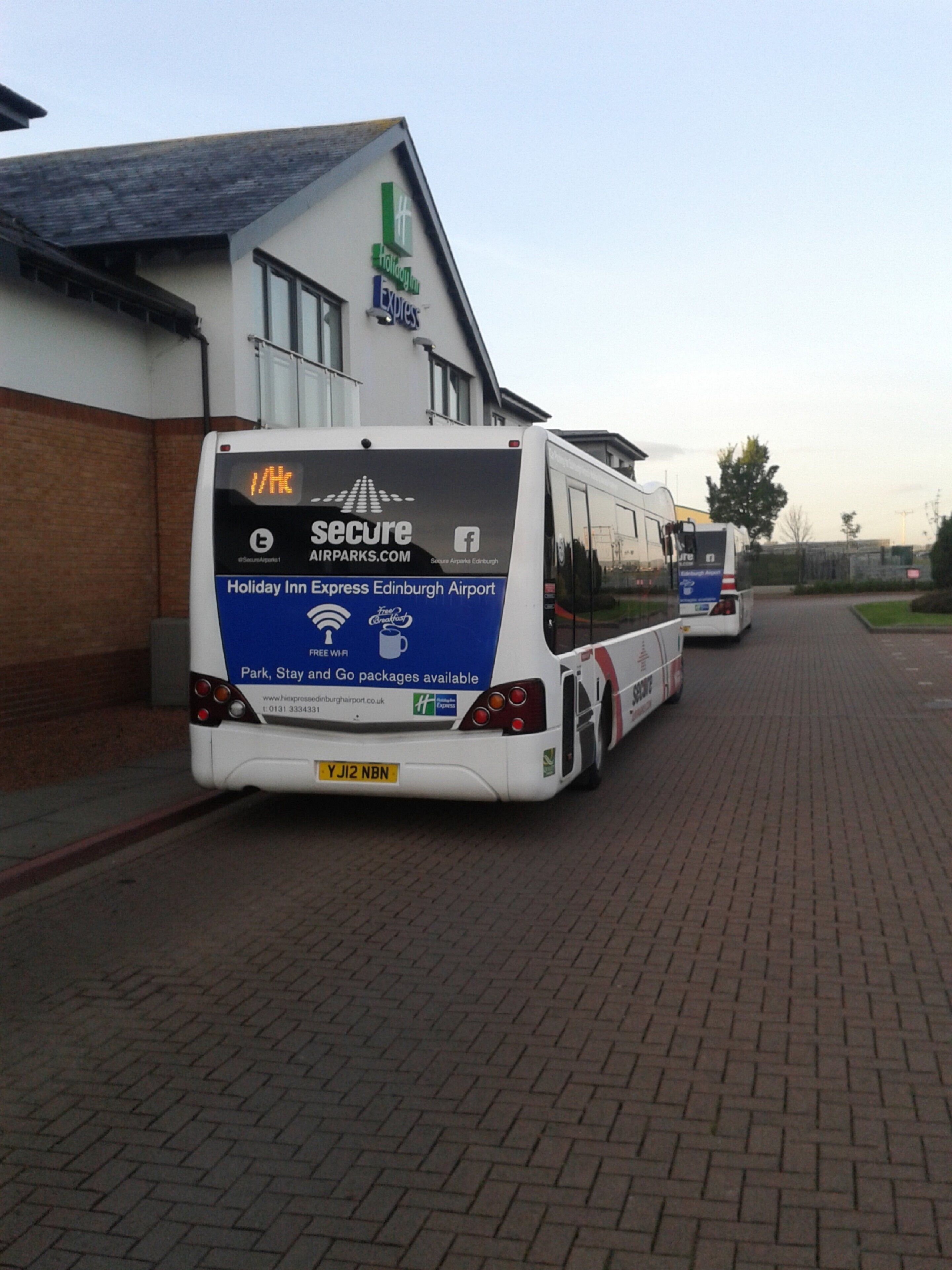 Een Holiday Inn Express bus geparkeerd bij een luchthaven.