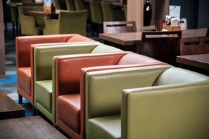 A row of booth-style seating with a wooden table in front. - Holiday Inn Express Edinburgh Airport by IHG (Newbridge)