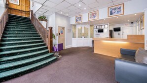 A hotel lobby with a staircase, reception desk, and seating area. - Comfort Inn Birmingham (Birmingham)