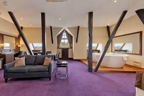 A spacious living area with a modern sofa, a fireplace, and a large window. - The Victoria Hotel, Bradford by Sunday (Bradford)