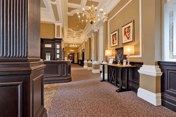 A grand hallway with ornate columns, a patterned carpet, and a chandelier. - The Victoria Hotel, Bradford by Sunday (Bradford)