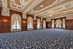 A large room with a patterned carpet, wooden paneling, and multiple windows with curtains. - The Victoria Hotel, Bradford by Sunday (Bradford)