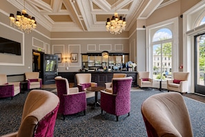 A hotel lobby with a bar area, seating arrangements, and large windows offering a view. - The Victoria Hotel, Bradford by Sunday (Bradford)
