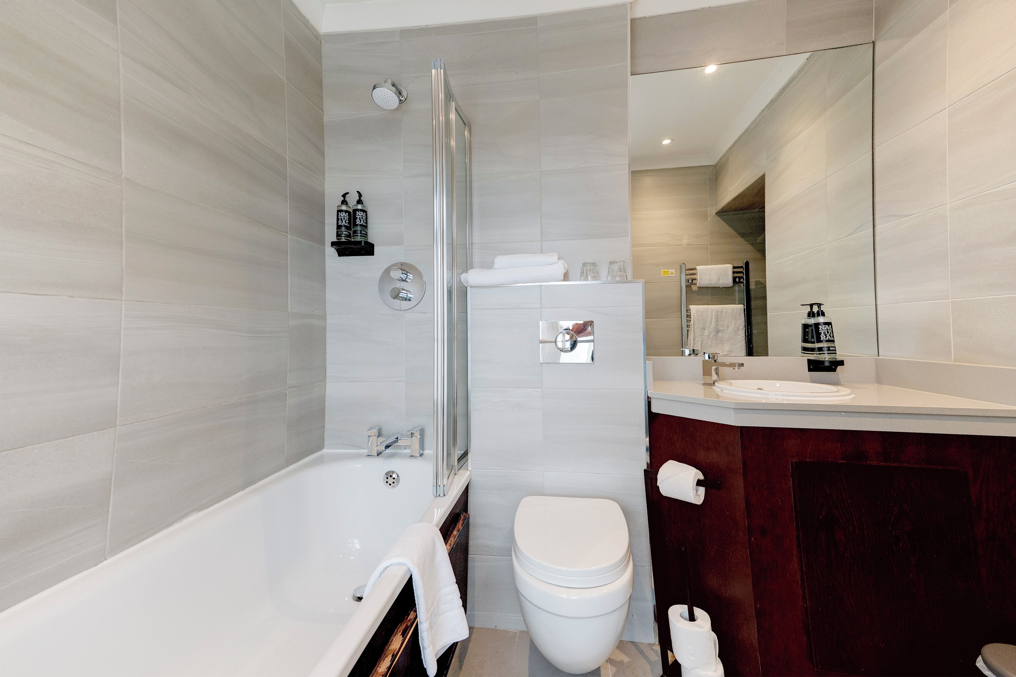 Un baño moderno con bañera, inodoro y ducha.