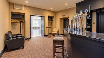 Un vestíbulo de hotel con zona de bar, asientos y vistas al exterior.
