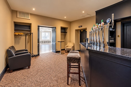 A hotel lobby with a bar area, seating, and a view to the outside.