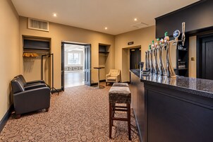Un vestíbulo de hotel con zona de bar, asientos y vistas al exterior.