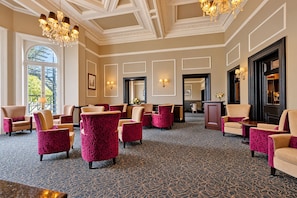 A hotel lobby with patterned carpet, multiple seating areas, chandeliers, and framed artwork on the walls. - The Victoria Hotel, Bradford by Sunday (Bradford)