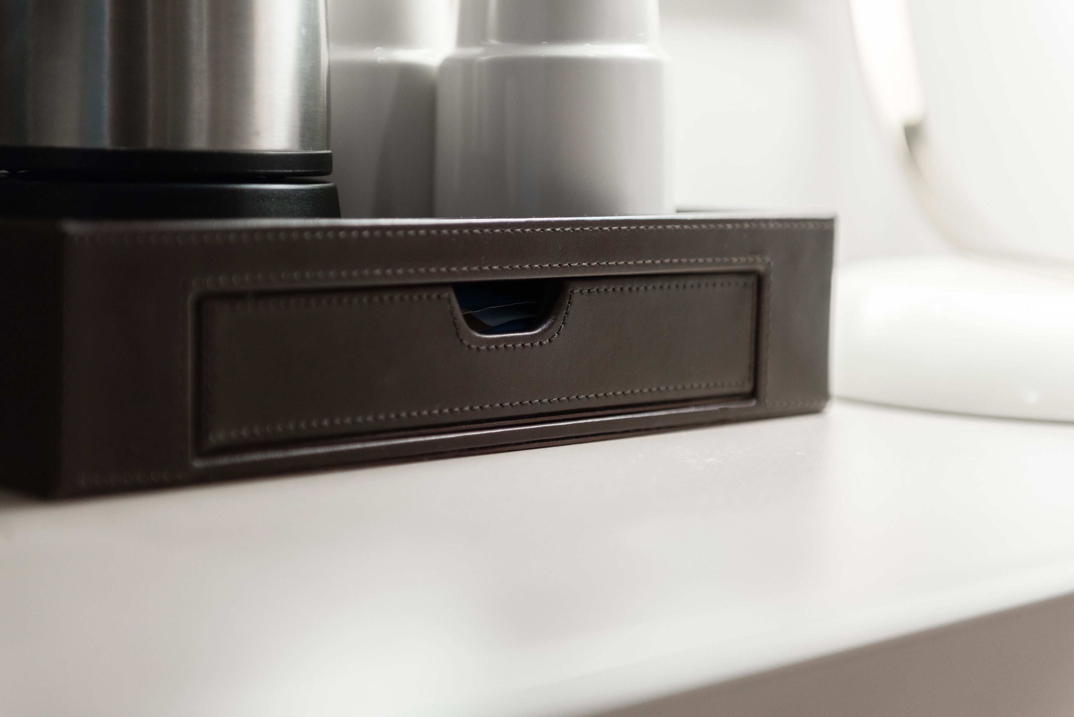A black leather case with a zipper on a white surface.