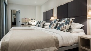 A modern bedroom with a large bed, bedside tables, and a nightstand. - Blandford Hotel (London)