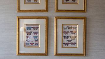 Quatre reproductions d’images de papillons, encadrées, sur un mur à texture.