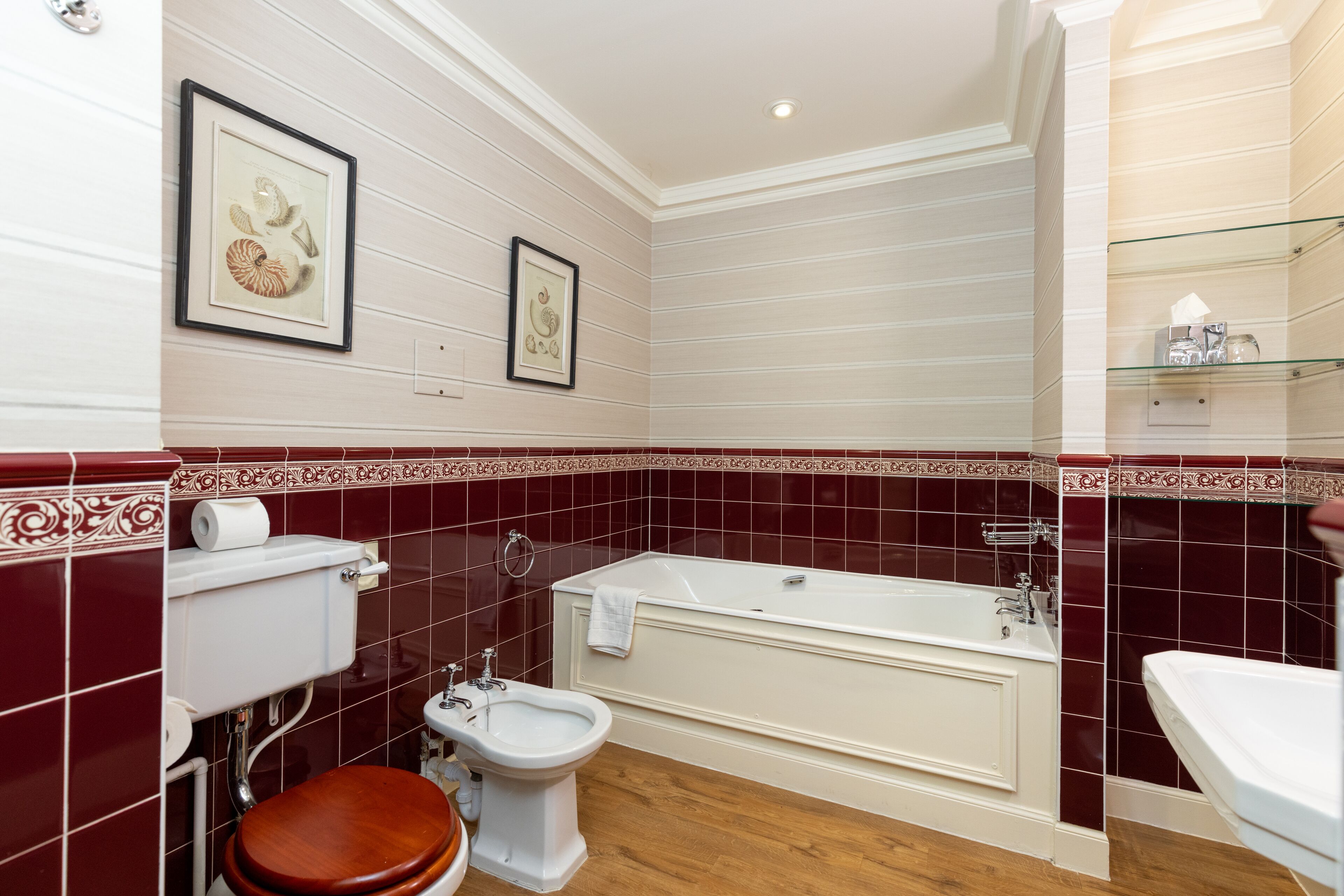A bathroom with a bathtub, a bidet, a toilet, and a sink.