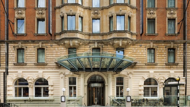 A historic building with a grand entrance, a glass canopy, and a classic architectural style. - The Memoir Club (London)