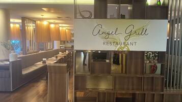 L’intérieur d’un restaurant, avec un comptoir en bois, un espace pour les clients et une enseigne indiquant « Angel Grill Restaurant ».