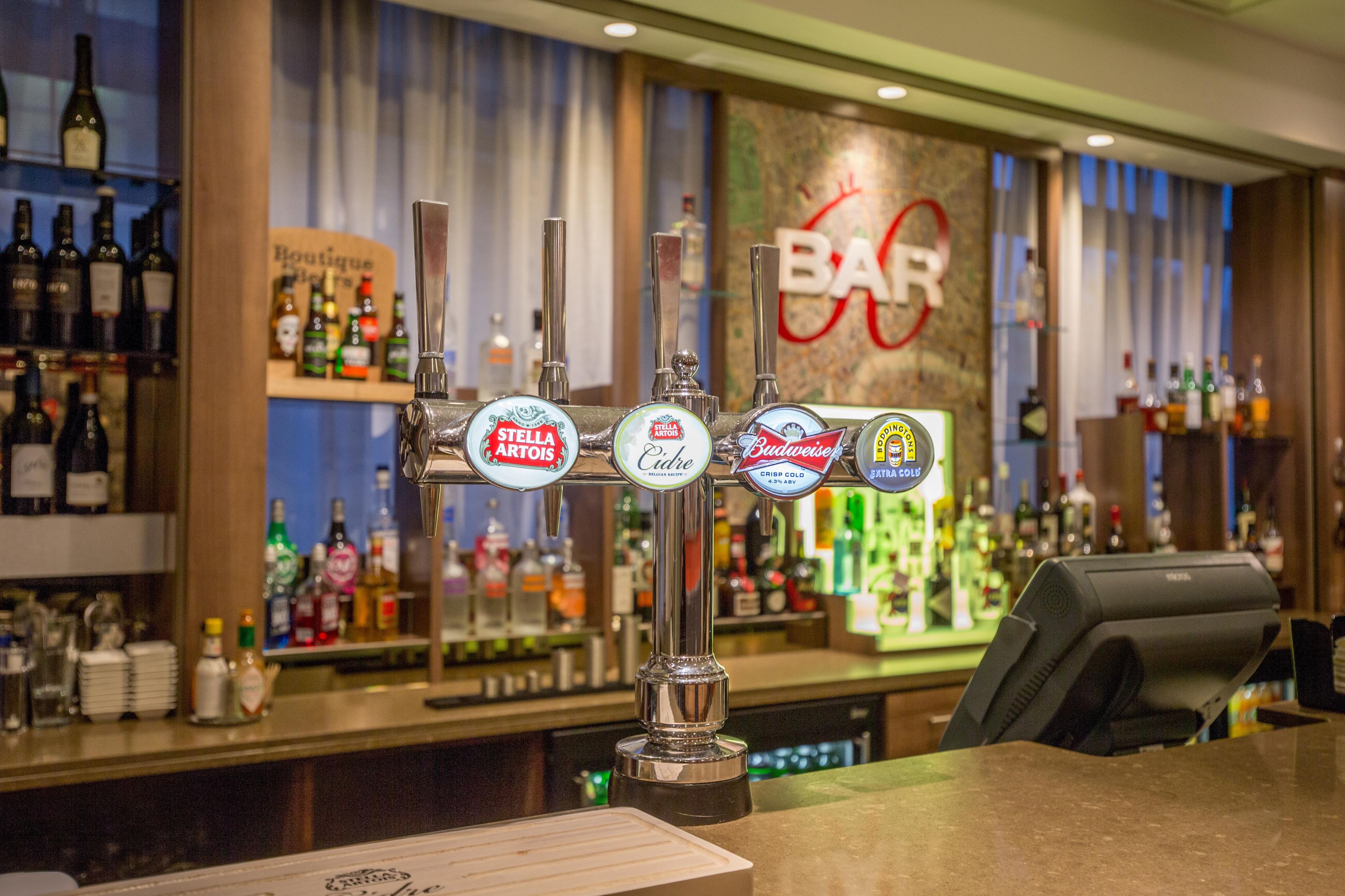 Un bar doté de plusieurs robinets, proposant des marques comme Stella Artois et Budweiser, et sur lequel on peut lire l’inscription « BAR ».