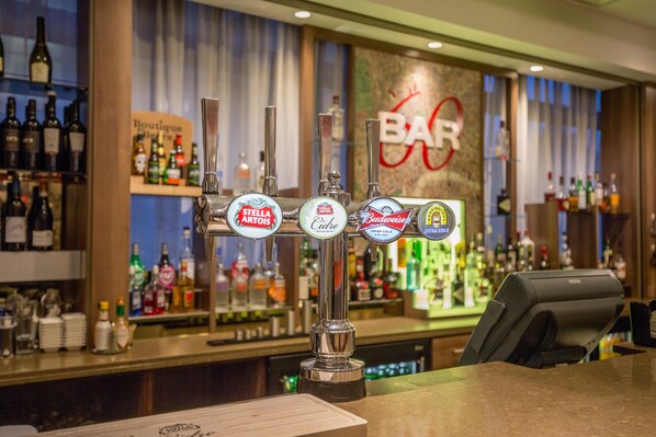 A bar with multiple taps, including brands like Stella Artois and Budweiser, and a sign that reads 'BAR'.