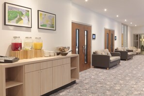 A modern hotel lobby with a reception desk, seating area, and artwork on the walls. - DoubleTree by Hilton London Angel Kings Cross (London)