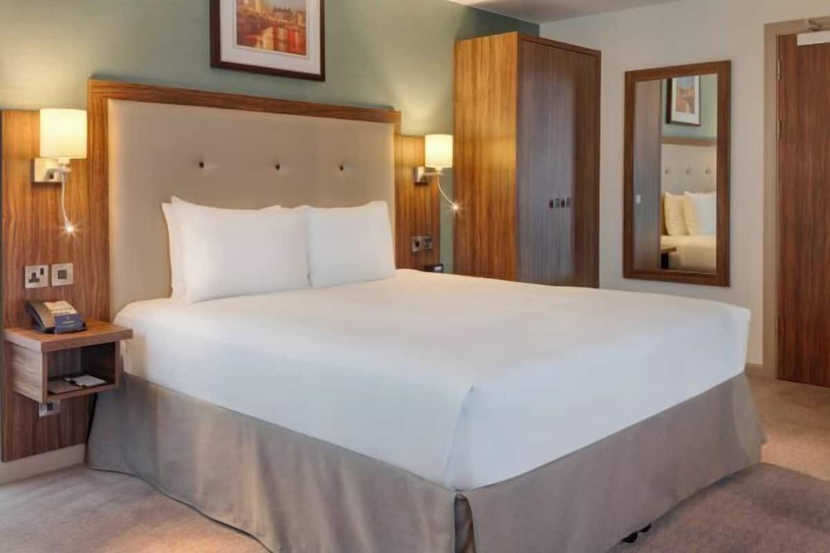 Ropa de cama hipoalergénica y caja de seguridad en la habitación