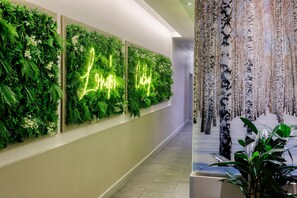 A hallway with vertical gardens and a neon sign. - DoubleTree by Hilton London Angel Kings Cross (London)