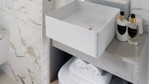 A modern bathroom with a large mirror, two sinks, and marble walls. - Montcalm Mayfair Townhouse (London)