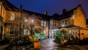 A traditional stone building with a central entrance, surrounded by well-maintained shrubbery and potted plants. - The Old Golf House, Sure Hotel Collection by Best Western (Huddersfield)