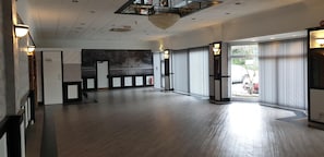 Eine geräumige Hotelhalle mit hoher Decke, großen Fenstern und einer Kristallleuchter.