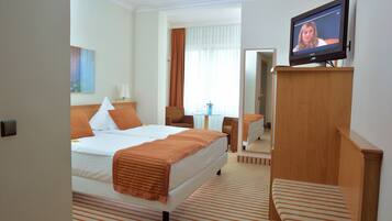 Een hotelkamer met een bed, een televisie, een bureau en een stoel.