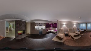 Een moderne woonkamer met een open haard, zithoek en een keukenblad.