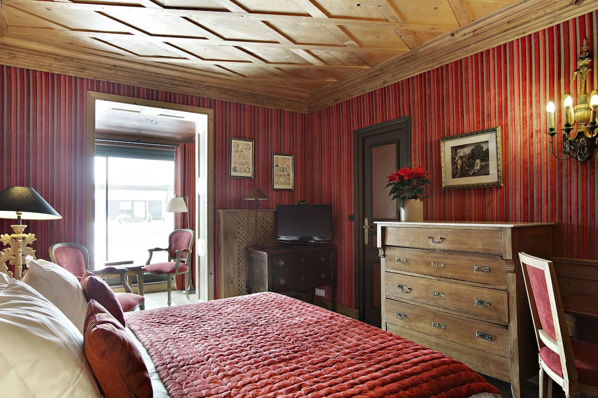A room with a bed, a dresser, a television, and a chair.