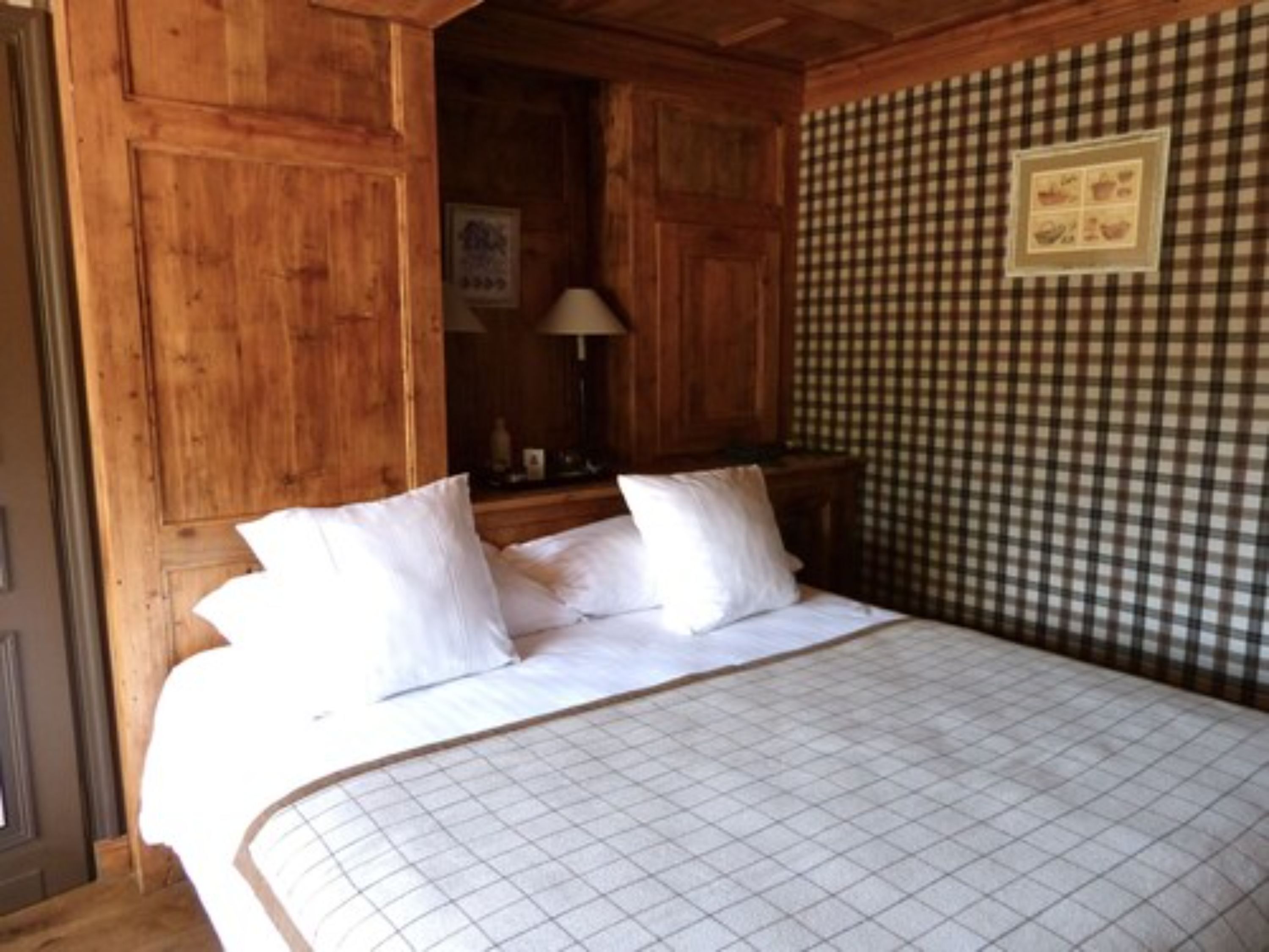 Une pièce en bois avec un lit, une table de chevet et un mur à carreaux.