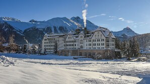 A large, historic hotel with multiple stories, surrounded by snow-covered mountains and a clear sky. - Cresta Palace (Celerina-Schlarigna)