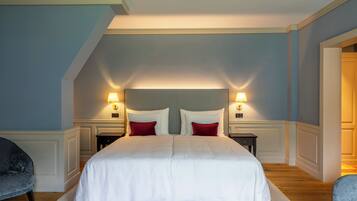 A bedroom with a large bed, two bedside tables, and a nightstand.