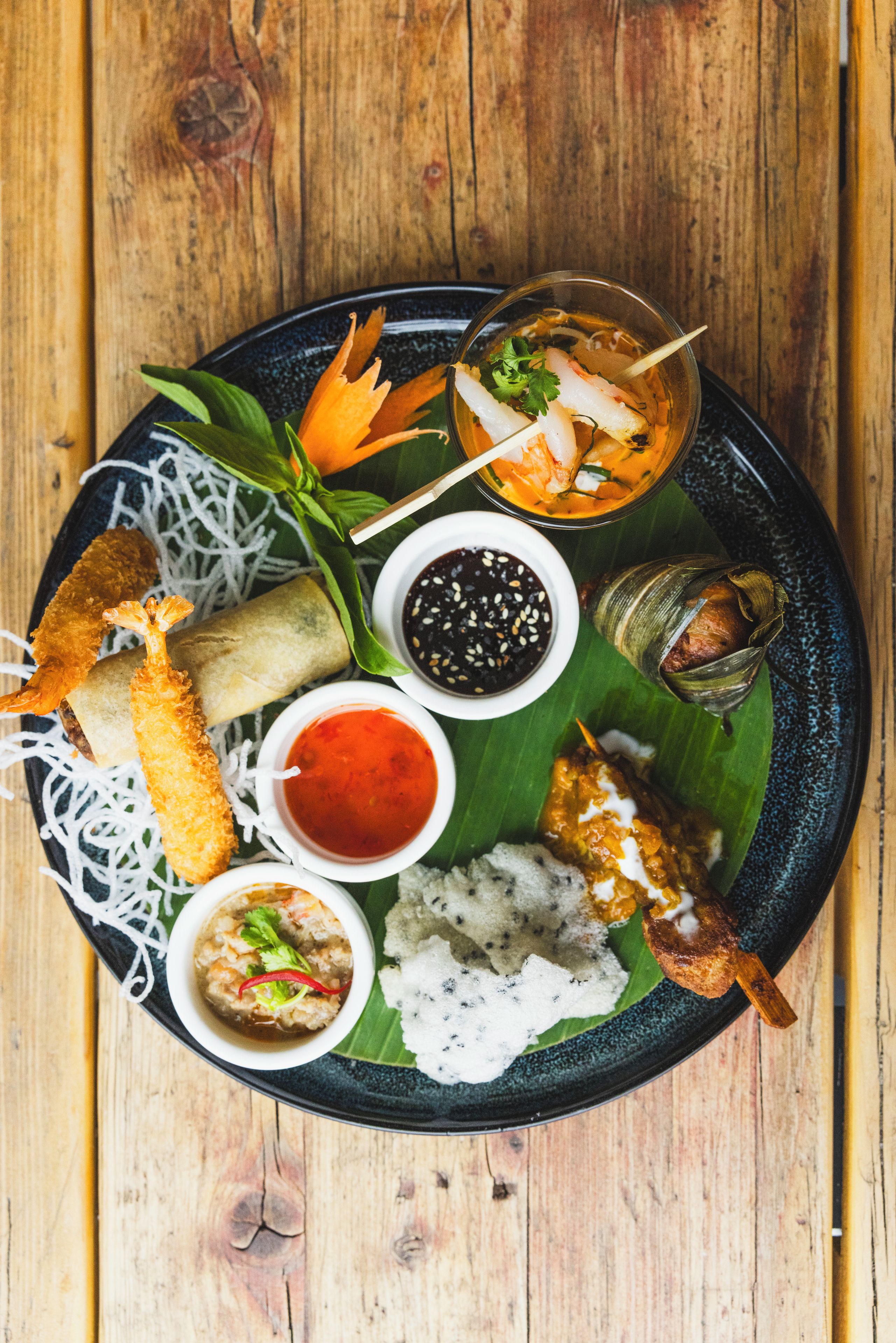 A plate of food with various dishes including a fish, rice, and vegetables.