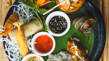 A plate of food with various dishes including a fish, rice, and vegetables.