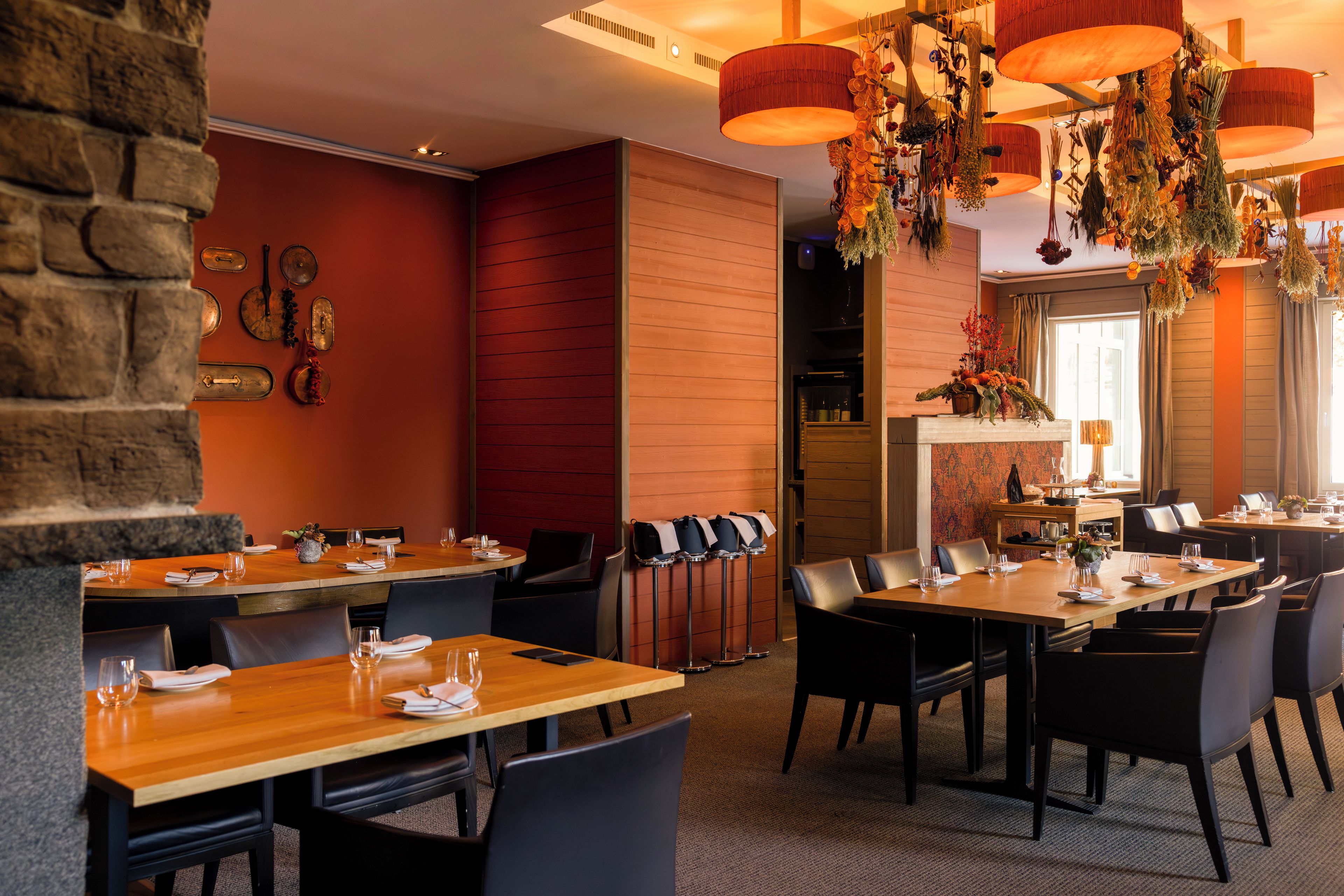 Un restaurante con varias mesas, sillas y una variedad de decoraciones colgantes.