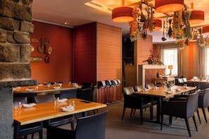 A restaurant with multiple dining tables, chairs, and a variety of hanging decorations. - Cresta Palace (Celerina-Schlarigna)