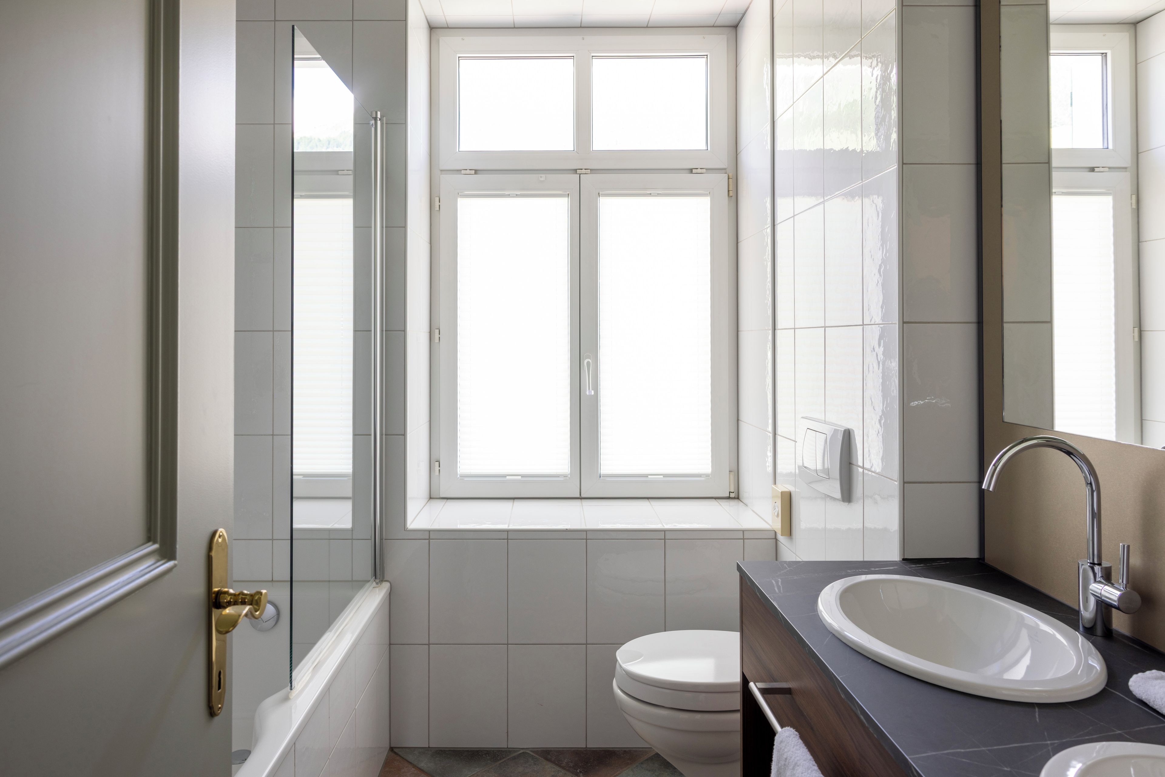A bathroom with a bathtub, toilet, and sink.
