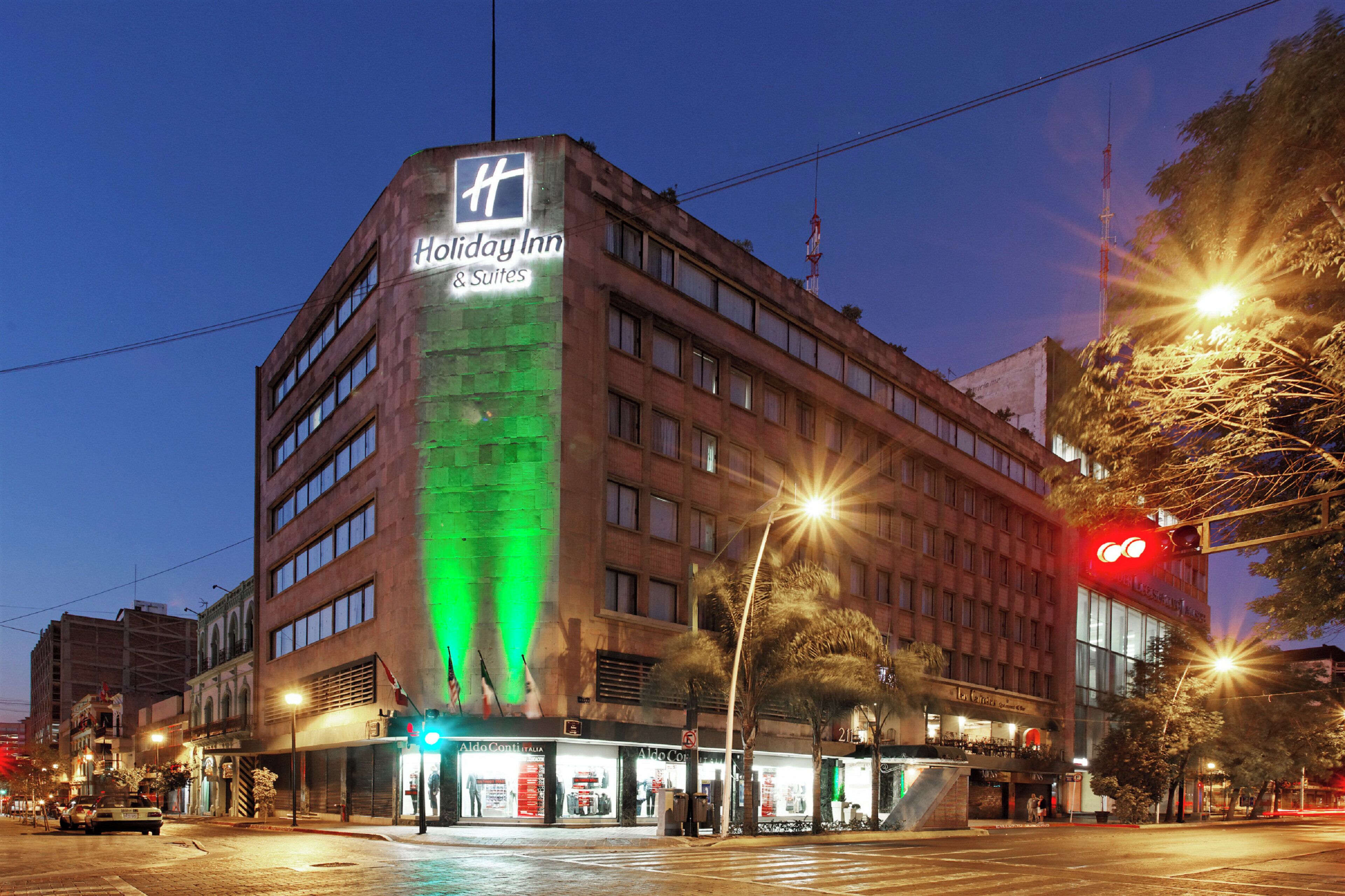 Edifici de Holiday Inn & Suites amb un cartell ben visible, diversos pisos i una ubicació cantonera amb façana.