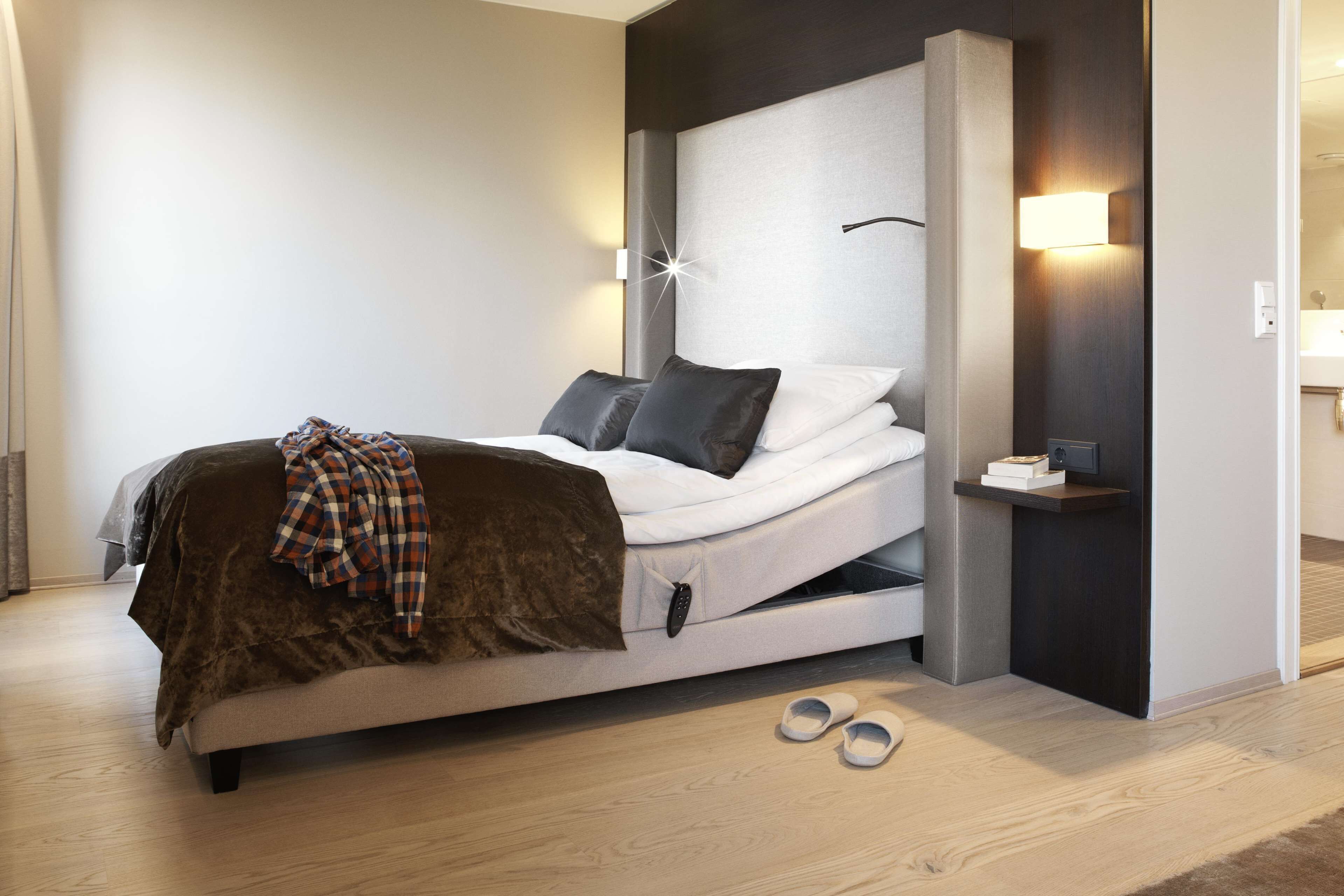 A modern bedroom with a bed, bedside tables, and a nightstand.