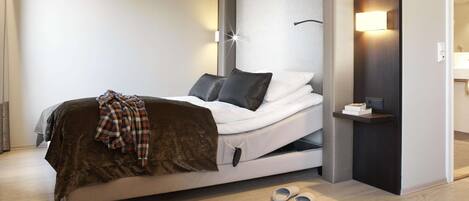 A modern bedroom with a bed, bedside tables, and a nightstand.