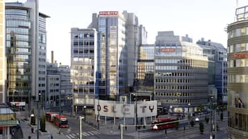 A modern urban street with high-rise buildings, including a prominent 'OSLCITY' sign.