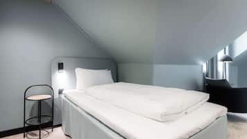 A modern bedroom with a bed, a small round table, and a chair.