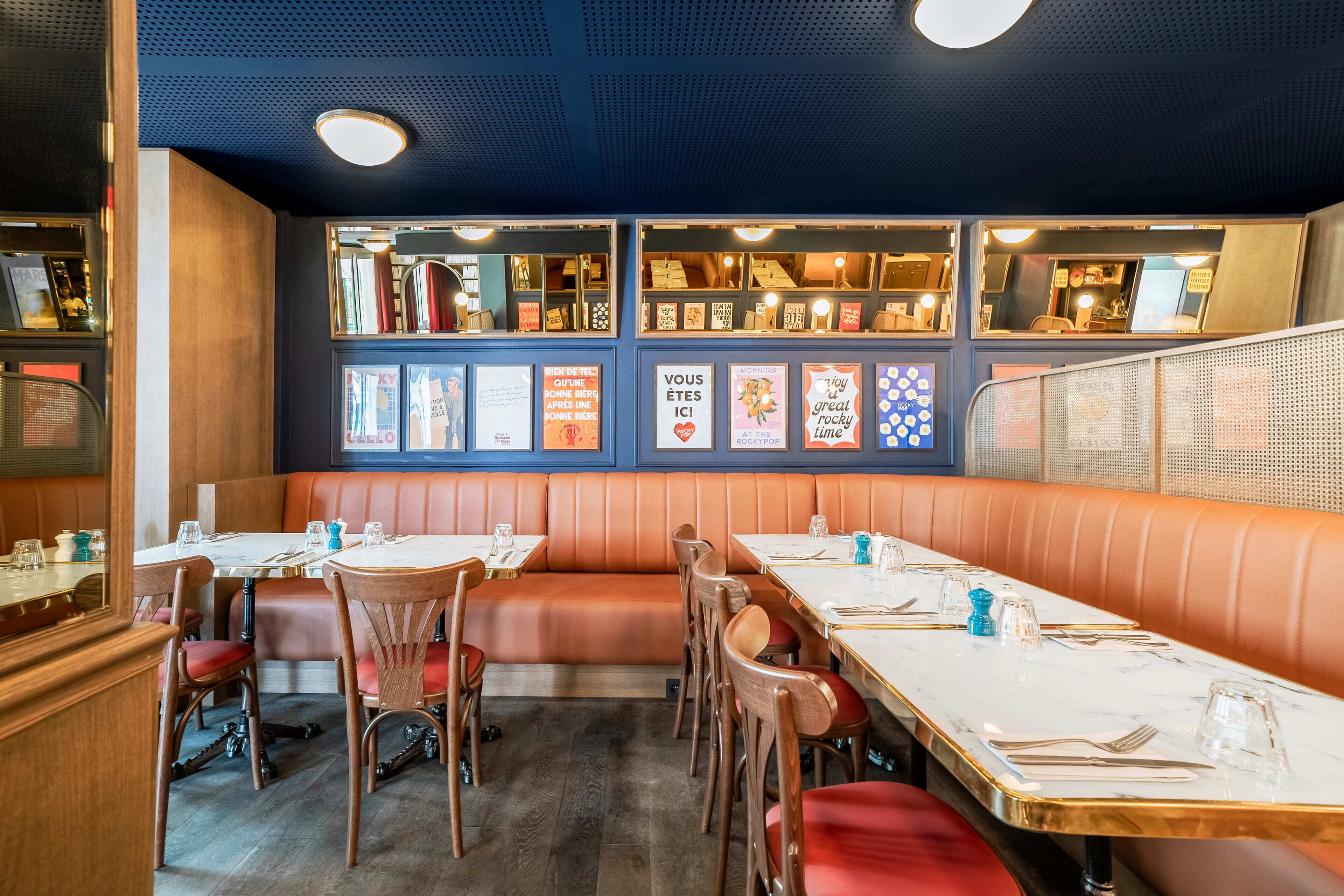 A restaurant interior with booths, tables, and framed artwork on the walls.