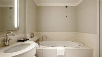 A bathroom with a sink, mirror, and bathtub.