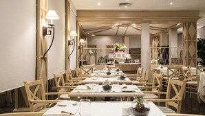 Un comedor con varias mesas y sillas, cada conjunto con platos, vasos y cubiertos.