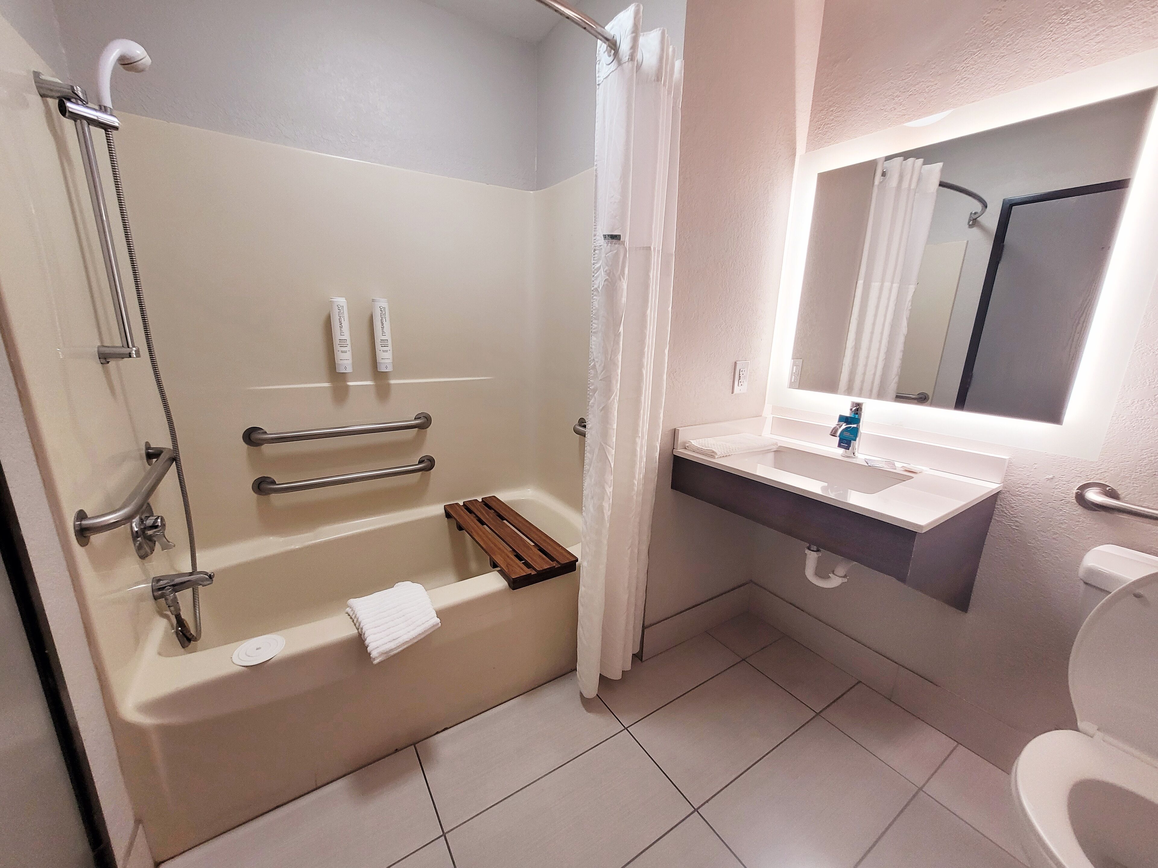 A bathroom with a bathtub, shower, and sink.